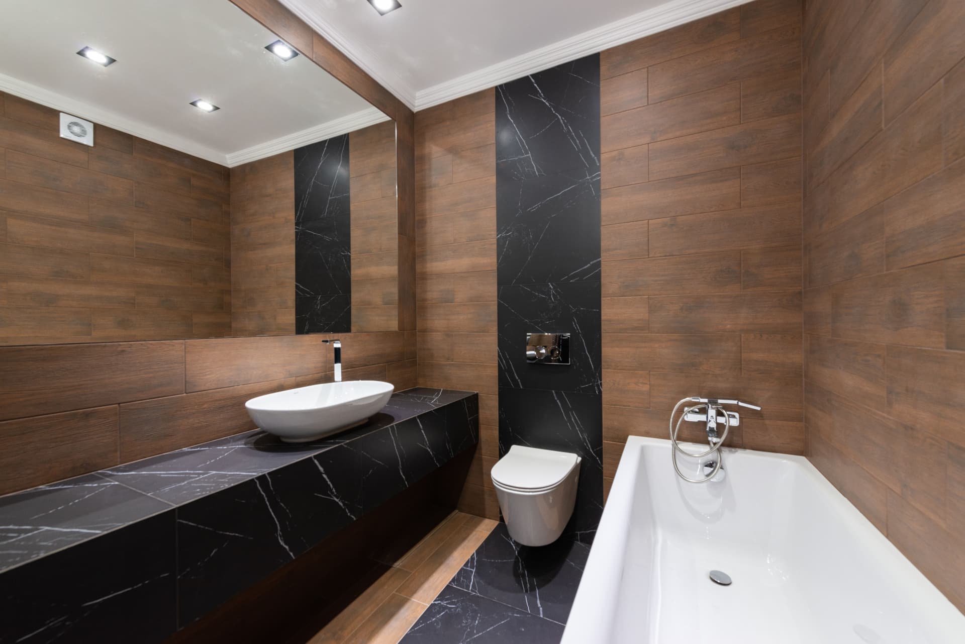 Polished modern bathroom with wood tile and black marble vanity